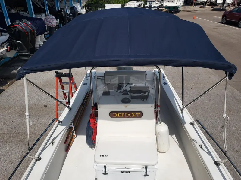 Slide: The Image of 2000 Eastern 19 Center Console boat with blue canopy docked at marina. - 4