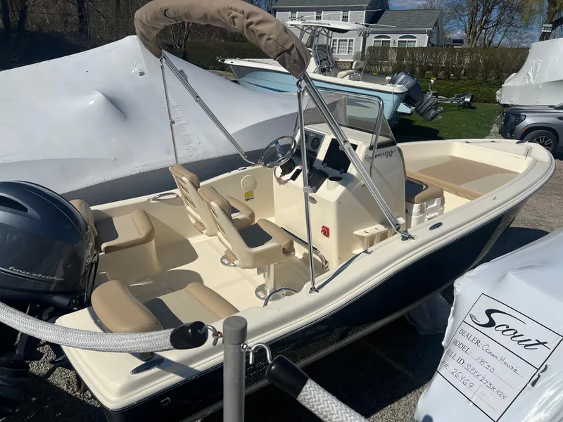 Slide: The Image of 2024 Scout 175 Sportfish boat with beige seating and outboard motor. - 2
