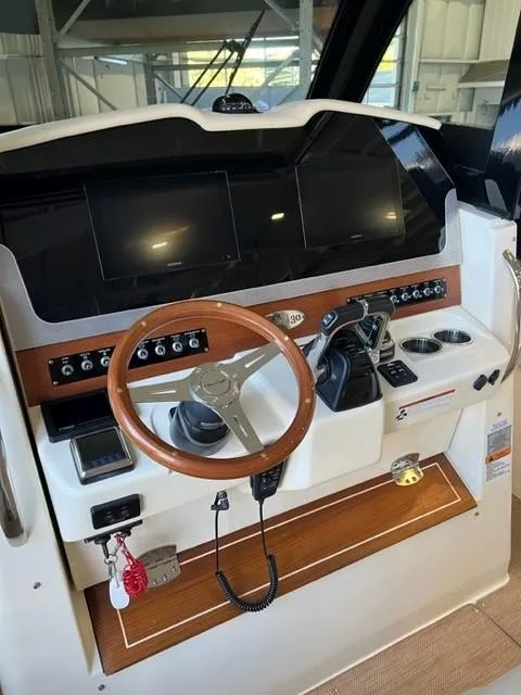 Slide: The Image of 2020 Chris-Craft Catalina 30 helm with wooden steering wheel and modern controls. - 13