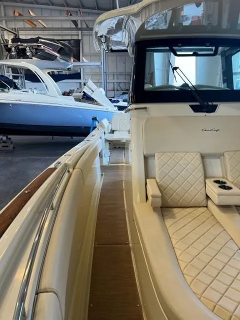 Slide: The Image of 2020 Chris-Craft Catalina 30 boat interior with white quilted seating in a marina. - 18