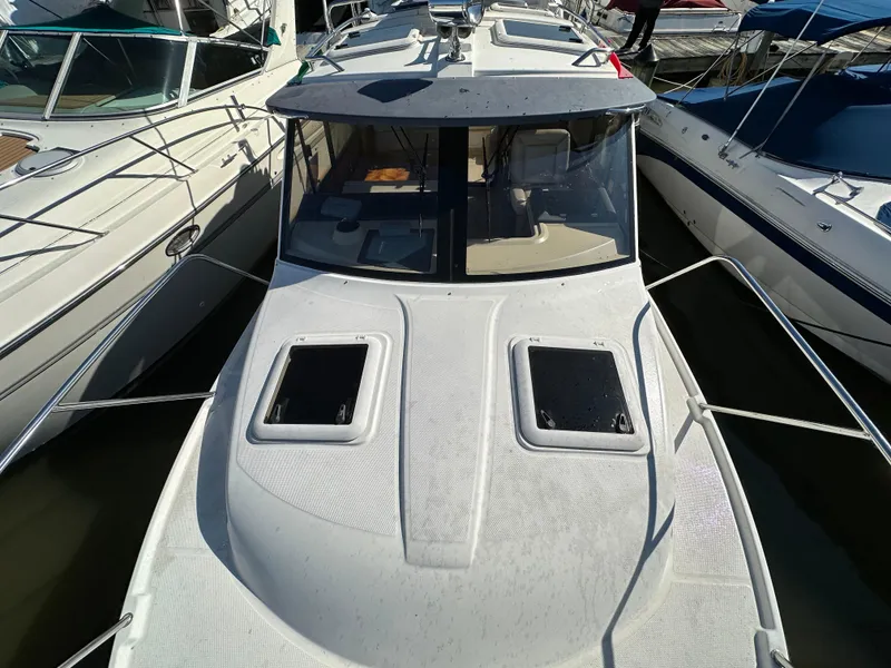 Slide: The Image of 2013 Cutwater 26 Coupe boat docked between other boats. - 44