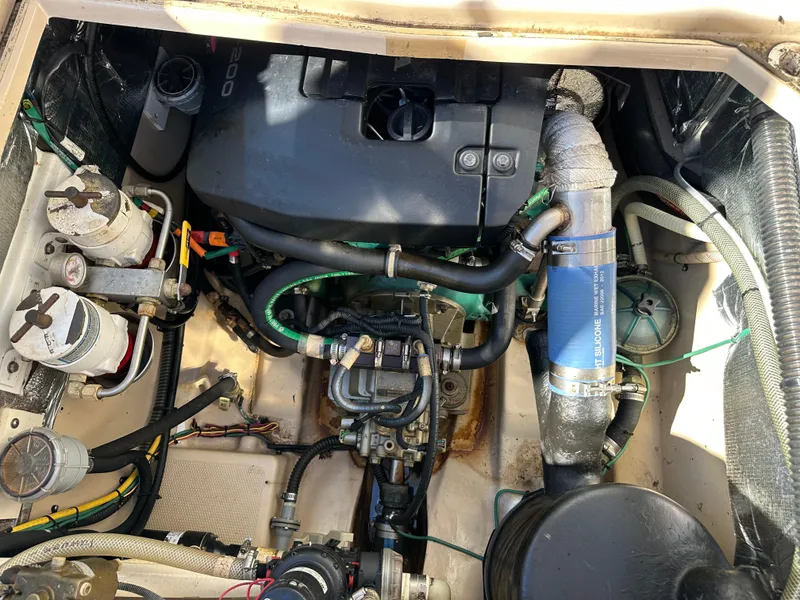 Slide: The Image of Engine compartment of a 2013 Cutwater 26 Coupe boat with visible components and hoses. - 49