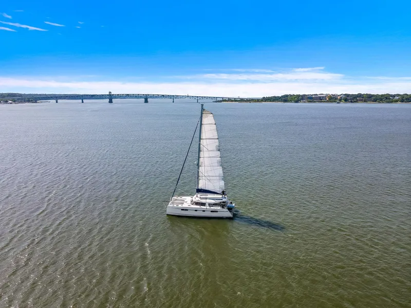Slide: The Image of Nautitech 46 Open catamaran sailing on a wide river under a clear blue sky. - 17