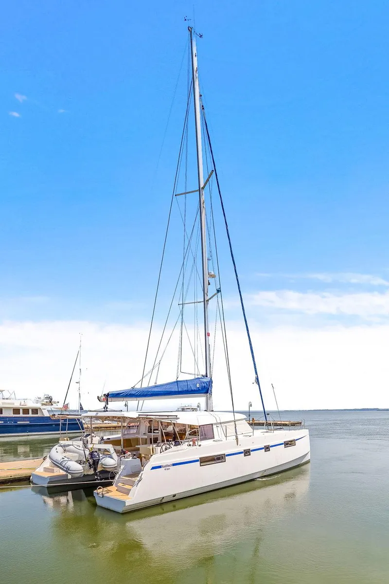 Slide: The Image of 2017 Nautitech 46 Open catamaran docked, featuring sleek design and spacious deck under clear blue sky. - 30