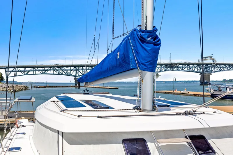 Slide: The Image of 2017 Nautitech 46 Open catamaran docked near a bridge, featuring a blue sail cover. - 32