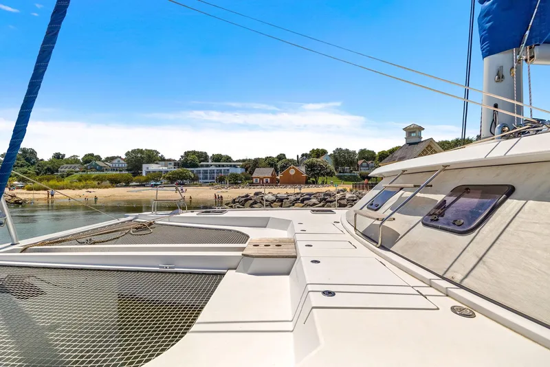 Slide: The Image of Nautitech 46 Open 2017 catamaran docked near a scenic shoreline under a clear blue sky. - 41