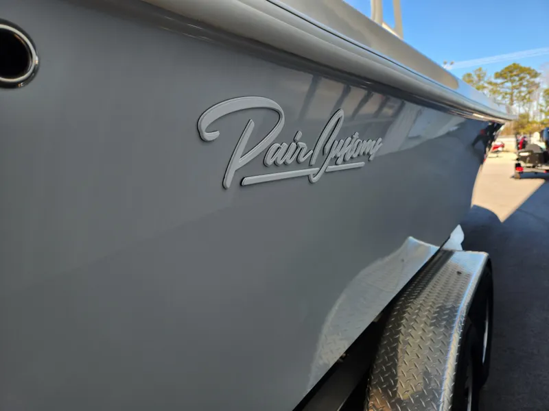 Slide: The Image of 2024 Pair Customs 27 CC boat on trailer, parked outdoors under clear sky. - 8