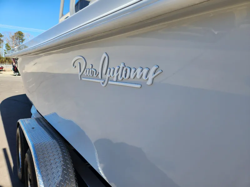 Slide: The Image of 2024 Pair Customs 27 CC boat with Garmin navigation, docked outdoors. - 9