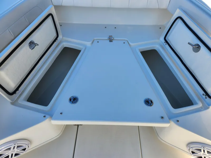 Slide: The Image of 2024 Pair Customs 27 CC boat interior with white seating and storage compartments. - 12