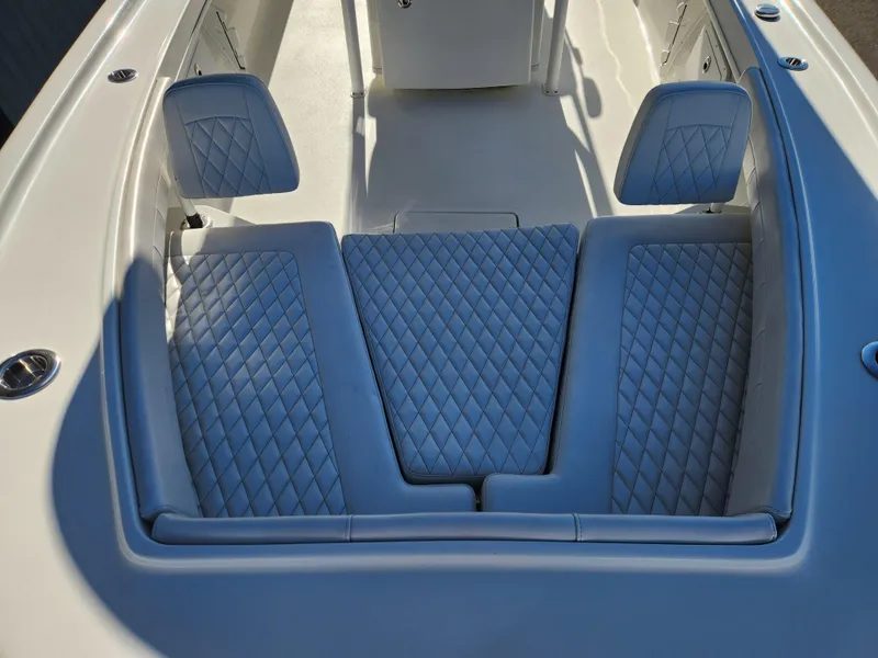 Slide: The Image of 2024 Pair Customs 27 CC boat interior with white cushioned seating and storage compartments. - 14