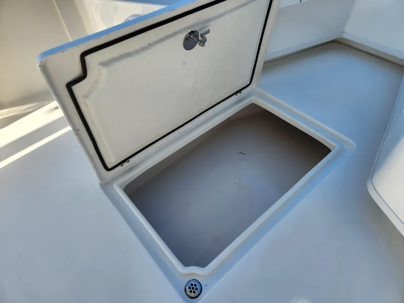 Slide: The Image of 2024 Pair Customs 27 CC boat with sleek design, parked outdoors near vehicles and trees. - 16