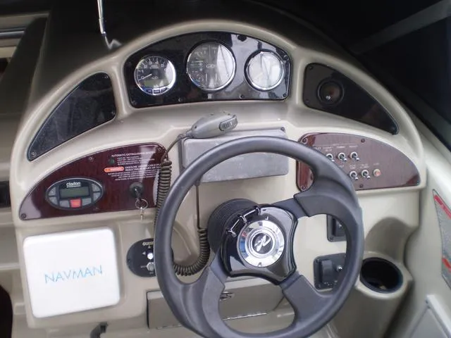 Slide: The Image of 2005 Sea Ray 260 Sundancer helm with steering wheel and navigation instruments. - 4