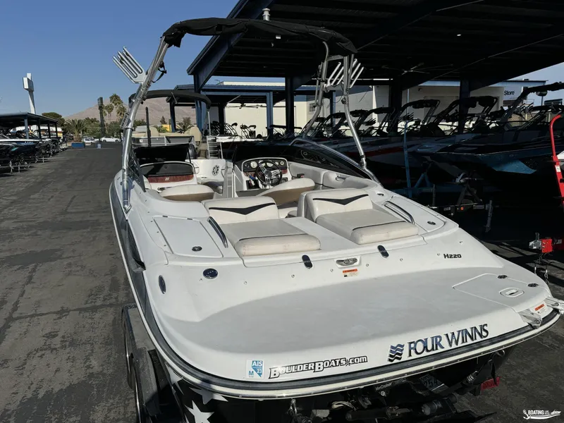 Slide: The Image of 2008 Four Winns Horizon 220SS boat with sleek design, parked in a marina. - 5