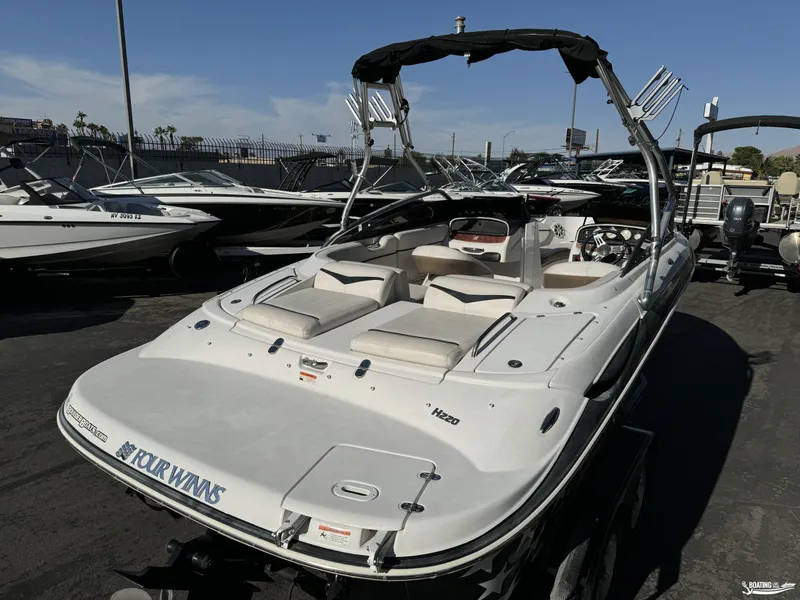 Slide: The Image of 2008 Four Winns Horizon 220SS boat with sleek design, docked in a marina. - 6