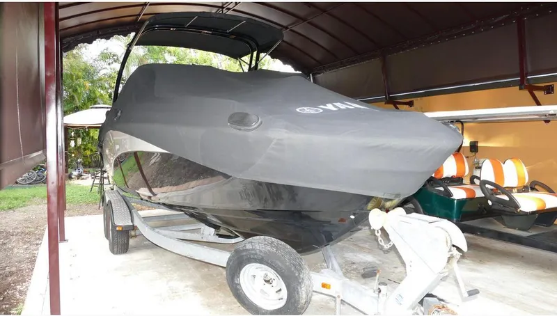 Slide: The Image of 2015 Yamaha AR240 boat covered and parked on a trailer in a sheltered area. - 18