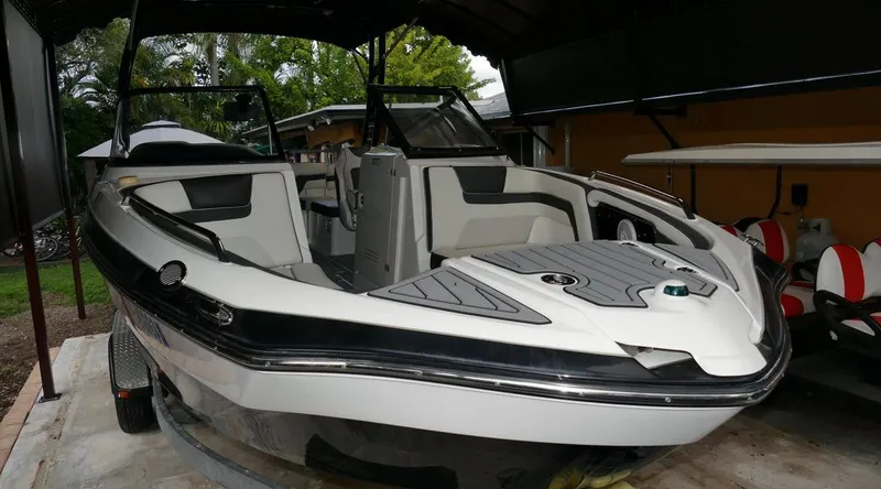 Slide: The Image of 2015 Yamaha Boats AR240 in a covered storage area, showcasing sleek design and spacious interior. - 2