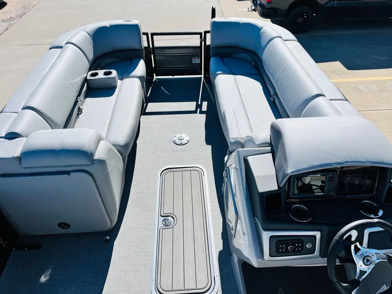 Slide: The Image of 2024 Regency 230 DL3 pontoon boat interior with gray seating and modern dashboard. - 11