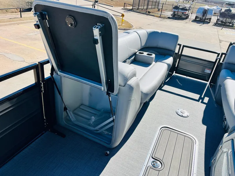 Slide: The Image of 2024 Regency 230 DL3 pontoon boat interior with storage compartment and seating. - 13