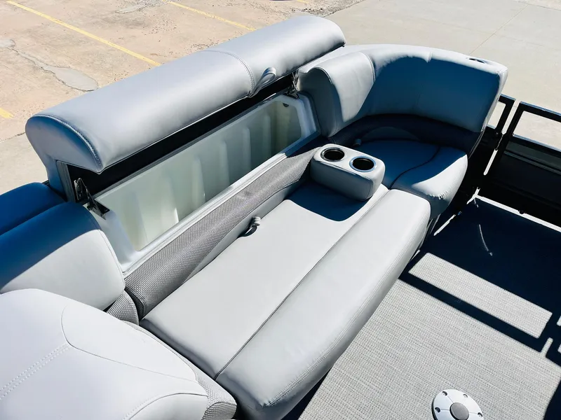 Slide: The Image of 2024 Regency 230 DL3 pontoon boat with gray cushioned seating and built-in storage compartment. - 15