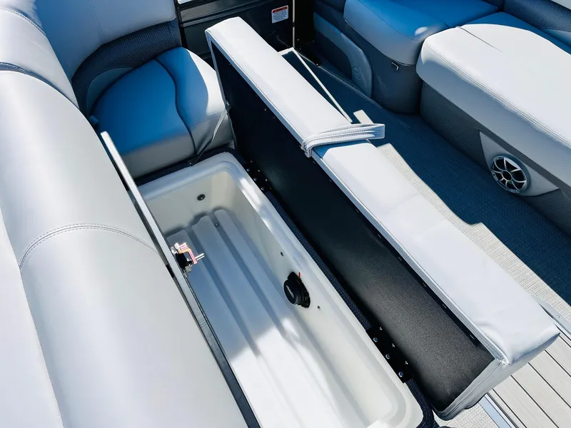Slide: The Image of 2024 Regency 230 DL3 boat with open storage compartment and cushioned seating. - 18
