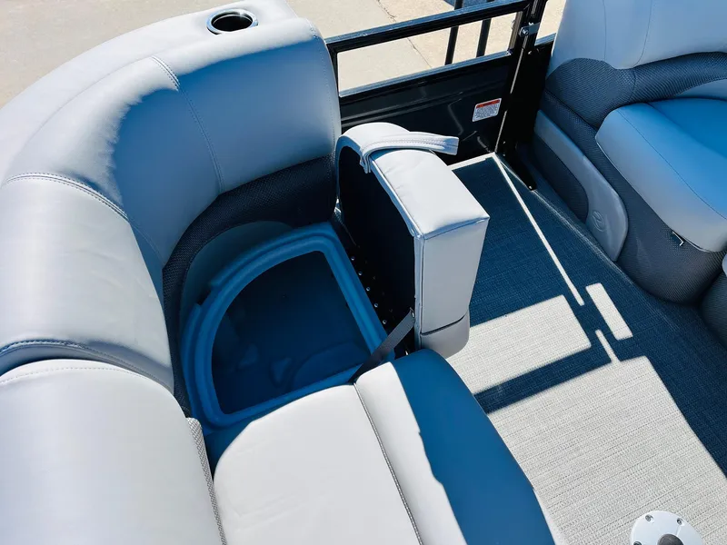 Slide: The Image of 2024 Regency 230 DL3 boat interior with storage compartment and cushioned seating. - 19