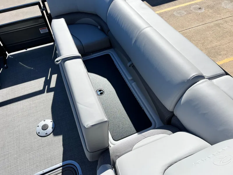 Slide: The Image of 2024 Regency 230 DL3 boat interior with gray cushioned seating and storage compartment. - 22