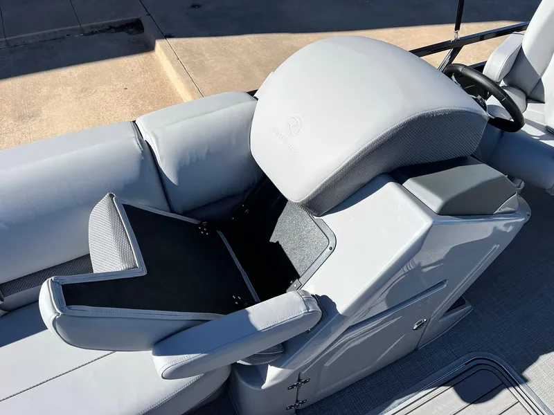 Slide: The Image of 2024 Regency 230 DL3 boat with open storage compartment and gray seating. - 25
