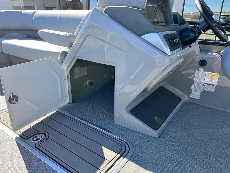 Slide: The Image of 2024 Regency 230 DL3 boat interior with open storage compartment and seating. - 29