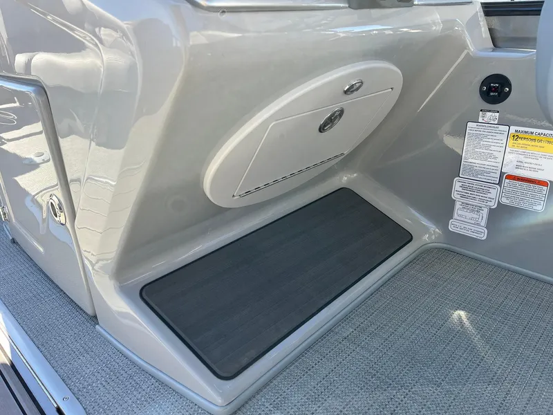 Slide: The Image of 2024 Regency 230 DL3 boat interior storage compartment and footrest. - 35