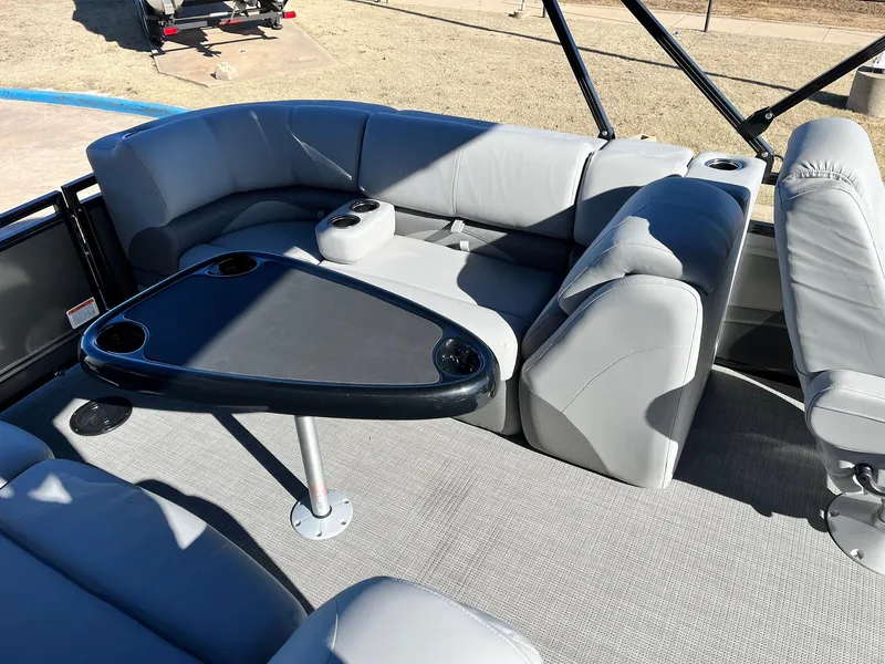 Slide: The Image of 2024 Regency 230 DL3 pontoon boat interior with gray seating and a black table. - 38