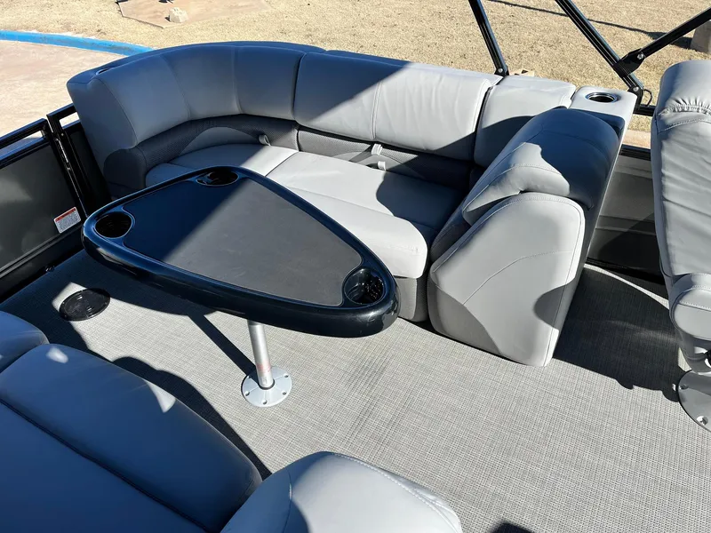 Slide: The Image of 2024 Regency 230 DL3 pontoon boat interior with gray seating and black table. - 39