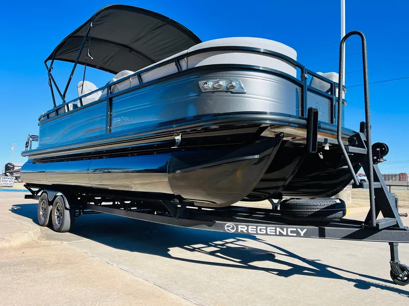 Slide: The Image of 2024 Regency 230 DL3 pontoon boat on trailer under clear blue sky. - 4