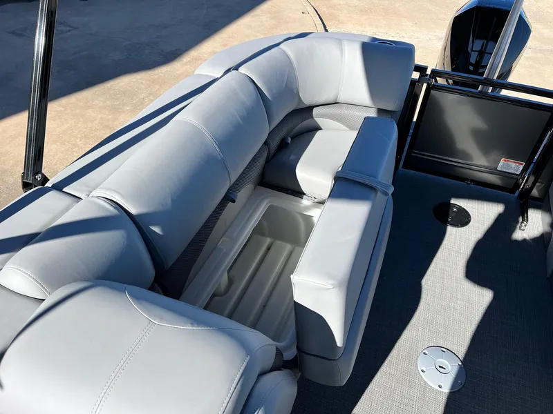 Slide: The Image of 2024 Regency 230 DL3 pontoon boat with gray cushioned seating and storage compartment. - 47