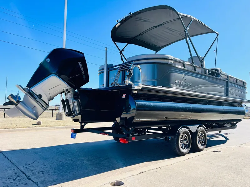 Slide: The Image of 2024 Regency 230 DL3 pontoon boat on trailer with outboard motor. - 6