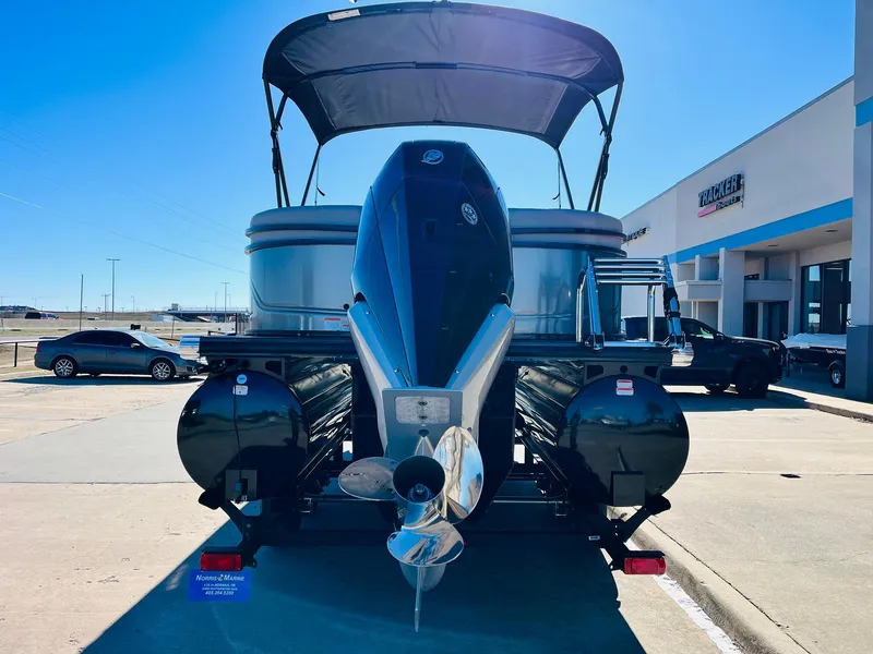 Slide: The Image of 2024 Regency 230 DL3 pontoon boat with canopy, rear view in dealership lot. - 7