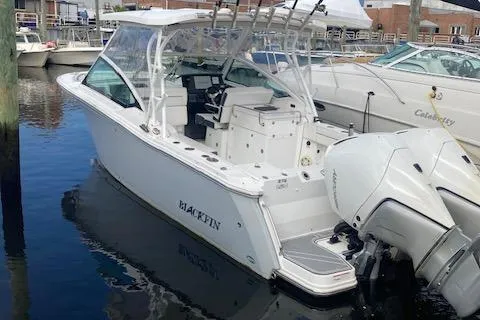 The Image of 2021 Blackfin 272DC boat docked in marina, rear view with twin outboard engines. - 0