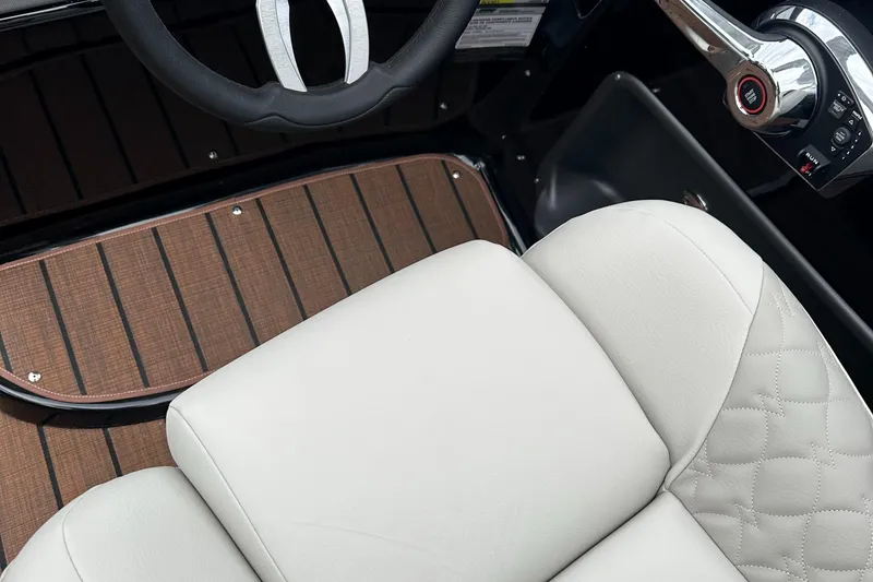 Slide: The Image of 2024 Manitou 25LX SRW boat interior with luxury seating and steering wheel. - 6
