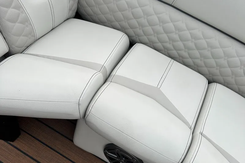Slide: The Image of 2024 Manitou 25LX SRW boat interior with white quilted seats. - 7