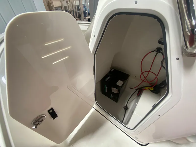 Slide: The Image of 2024 Key West 189 FS boat storage compartment with battery and wiring. - 13
