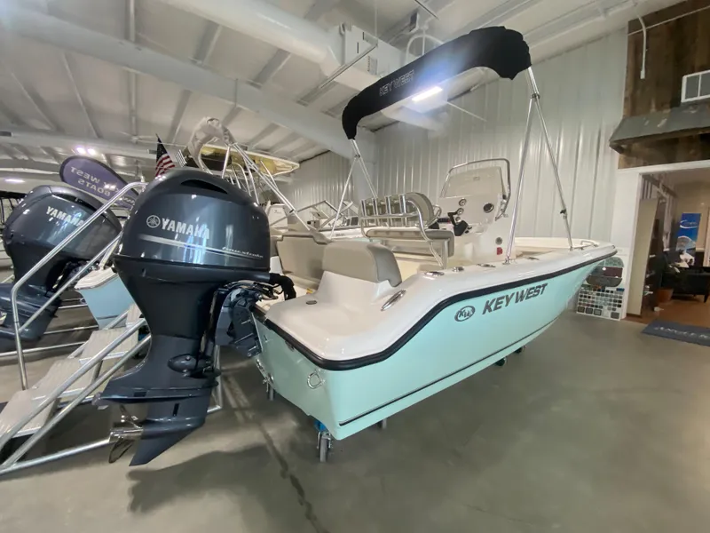 Slide: The Image of 2024 Key West 189 FS boat with Yamaha outboard motor in showroom. - 2