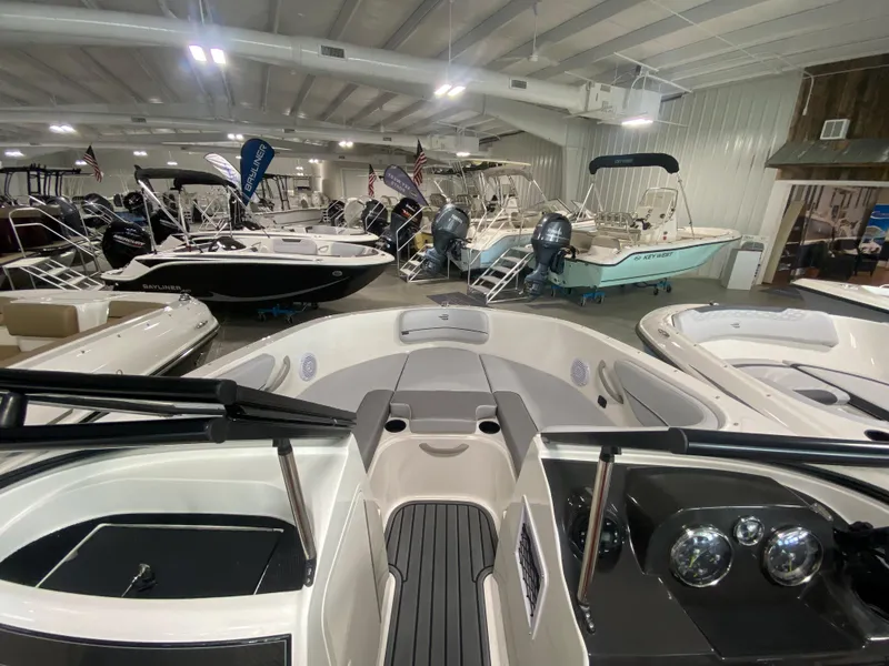 Slide: The Image of 2024 Bayliner VR4 boat displayed in a showroom with other boats. - 19