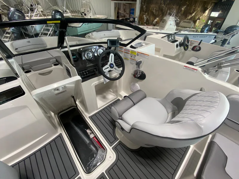 Slide: The Image of 2024 Bayliner VR4 boat interior with steering wheel and cushioned seating. - 12