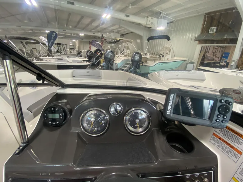 Slide: The Image of 2024 Bayliner VR4 boat dashboard with gauges and Lowrance display in showroom. - 15