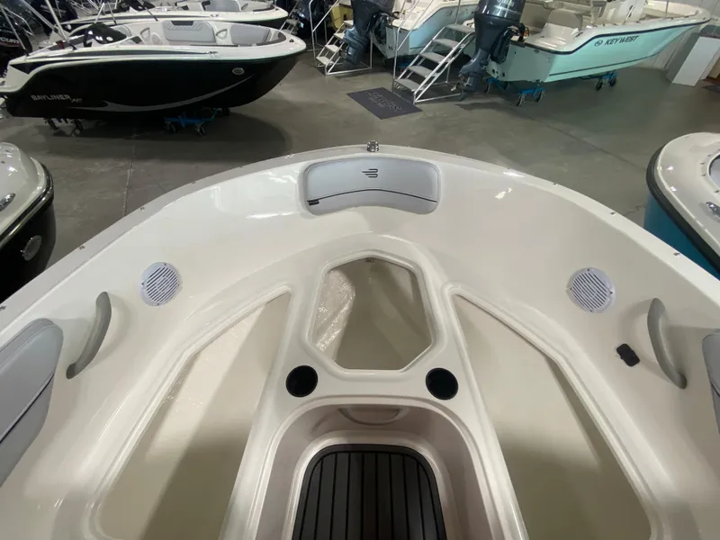 Slide: The Image of 2024 Bayliner VR4 boat interior, bow seating area with cup holders and storage compartments. - 22