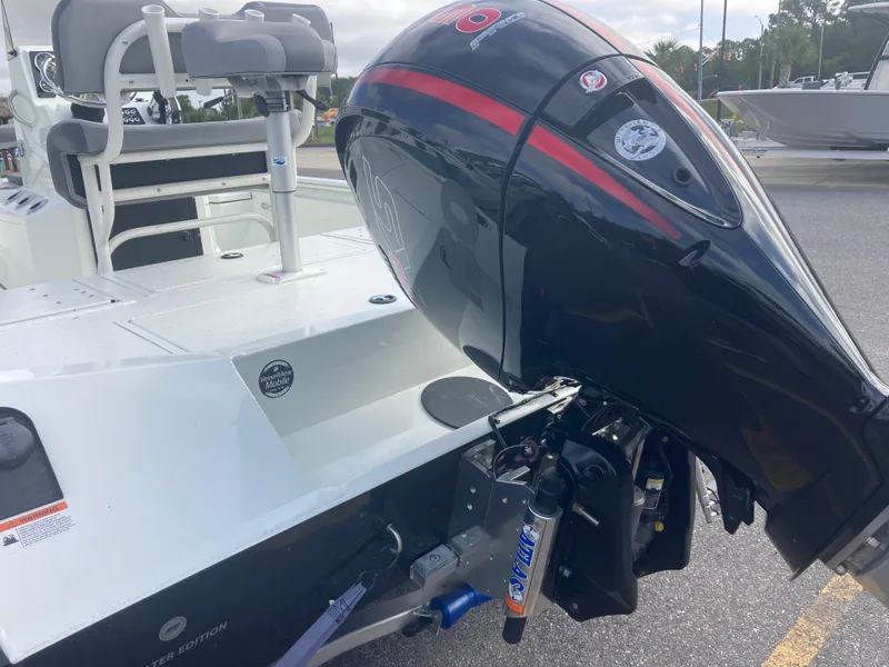 Slide: The Image of 2023 Lowe BAY 20 boat with outboard motor in a marina. - 2