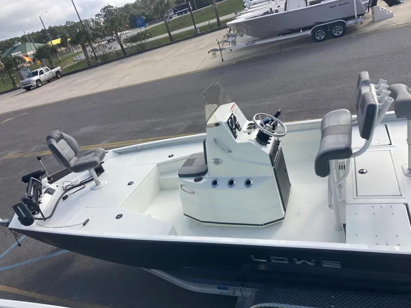 Slide: The Image of 2023 Lowe BAY 20 boat with center console and seating, parked on a trailer. - 3