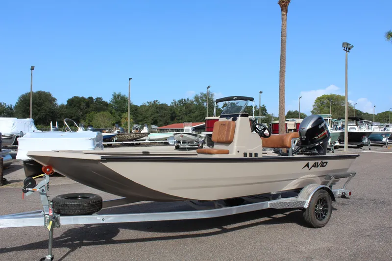 Slide: The Image of 2024 Avid 18 Rogue fishing boat on trailer in marina. - 2