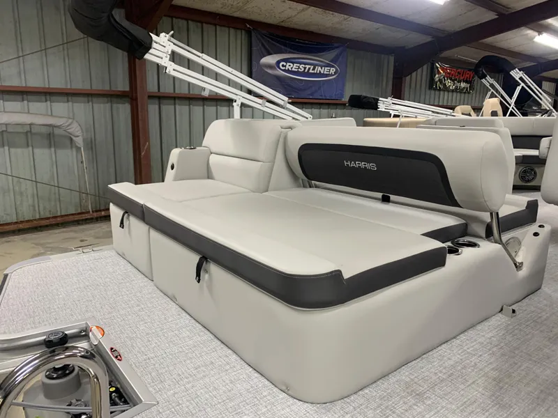 Slide: The Image of 2024 Harris Cruiser 190 boat interior with cushioned seating in a showroom. - 4