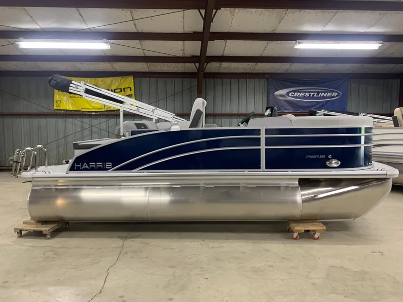 Slide: The Image of 2024 Harris Cruiser 190 pontoon boat in a showroom. - 6