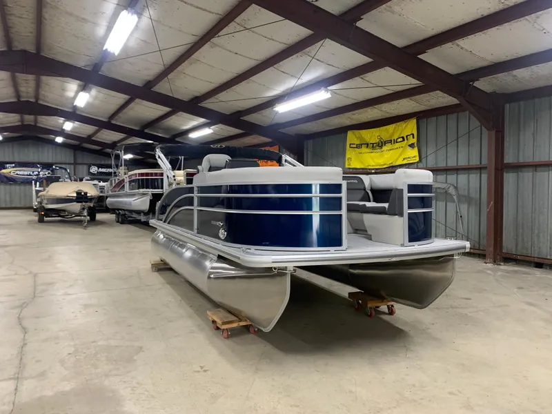 Slide: The Image of 2024 Harris Cruiser 190 pontoon boat in a storage facility. - 7